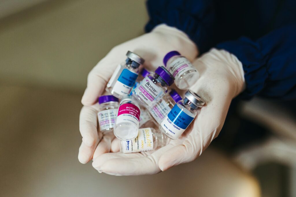 Close-up of gloved hands holding botulinum toxin vials in a laboratory, ideal for medical themes.