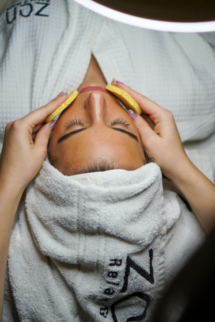 Relaxing spa treatment with facial and sponge massage in a serene environment.